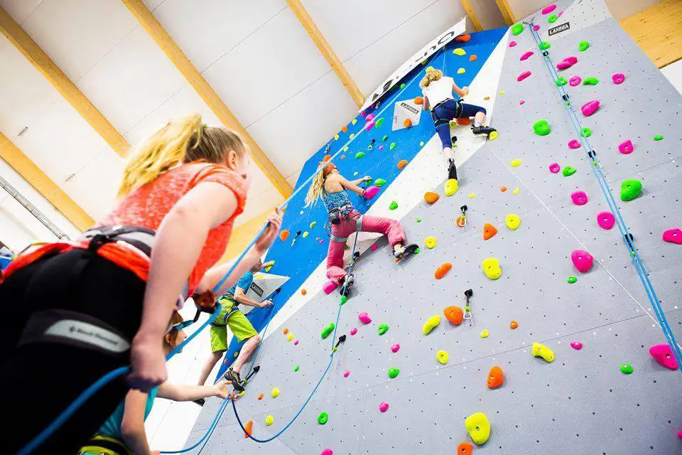 Ihmisiä kiipeilyseinällä