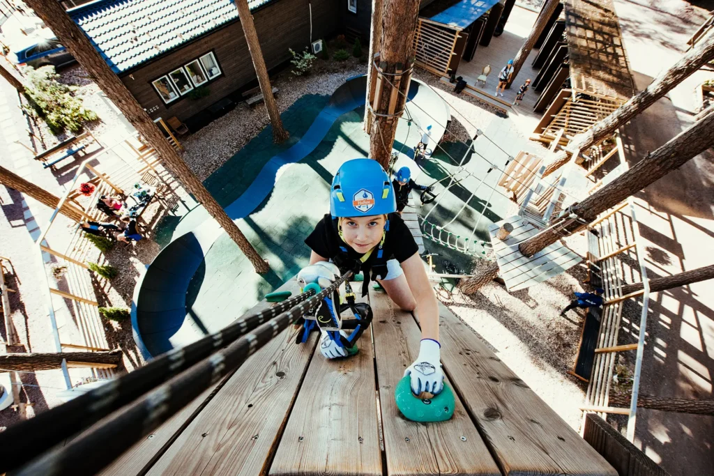 poika kiipeää ylös seinää seikkaulupuistossa