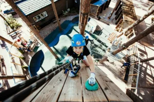 poika kiipeää ylös seinää seikkaulupuistossa